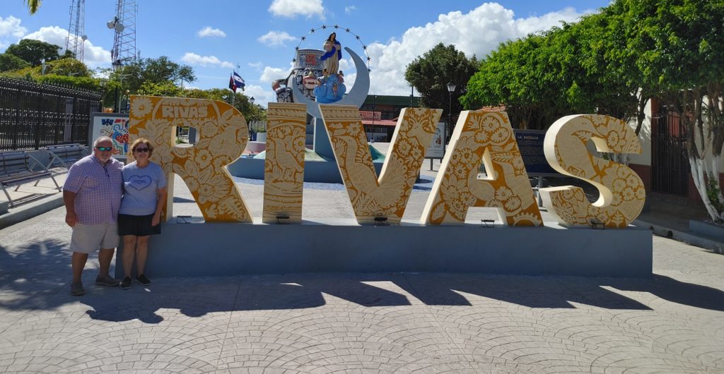 Ronny and Pam taking a picture with Rivas sign.